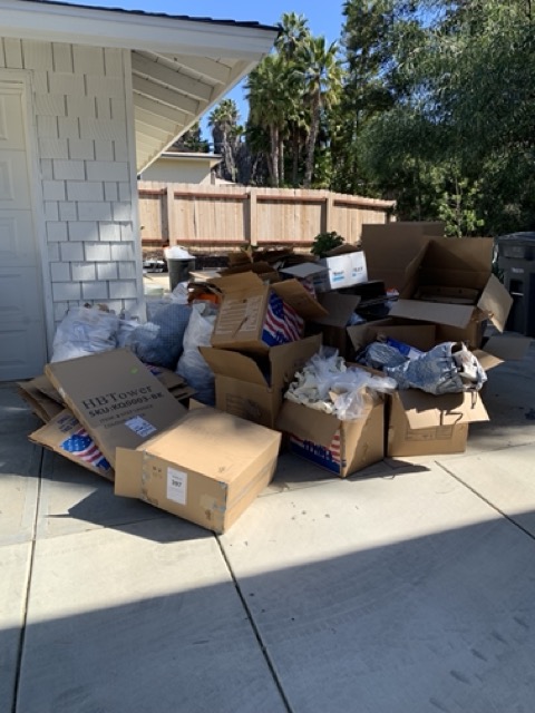 Cardboard boxes and trash bags piled on a patio for bulk junk haul-away